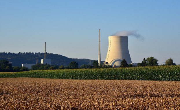 Kernkraftwerk Isar 2 mit einem großen Kühlturm in der Landschaft