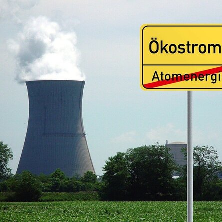 Kühlturm eines Kraftwerks mit Schild für Ökostrom